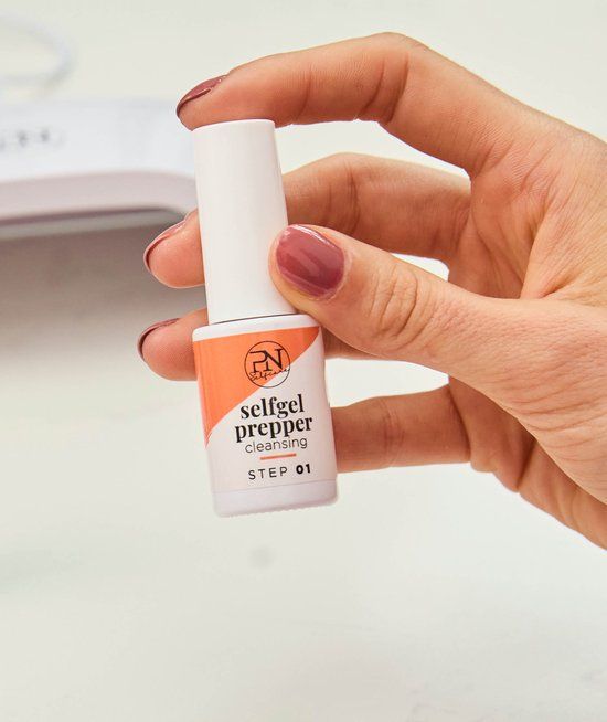 Hand hält Flasche mit weißem Deckel. Aufkleber mit PN-Logo, Schriftzug "selfgel prepper cleansing" und "STEP 01".