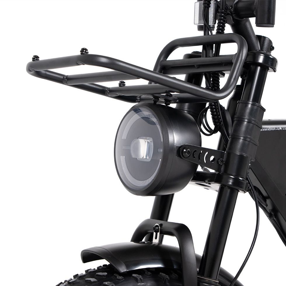 Nahaufnahme des schwarzen Scheinwerfers und Gepäckträgers eines E-Bikes. Runde Scheinwerferform.