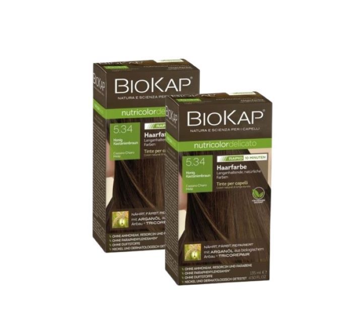 Zwei Kartons Biokap Haarfarbe 5.34 Honig Kastanienbraun. Verpackung mit Produktnamen, Farbnummer und Produktbezeichnung. Grün-braune Farbgebung.