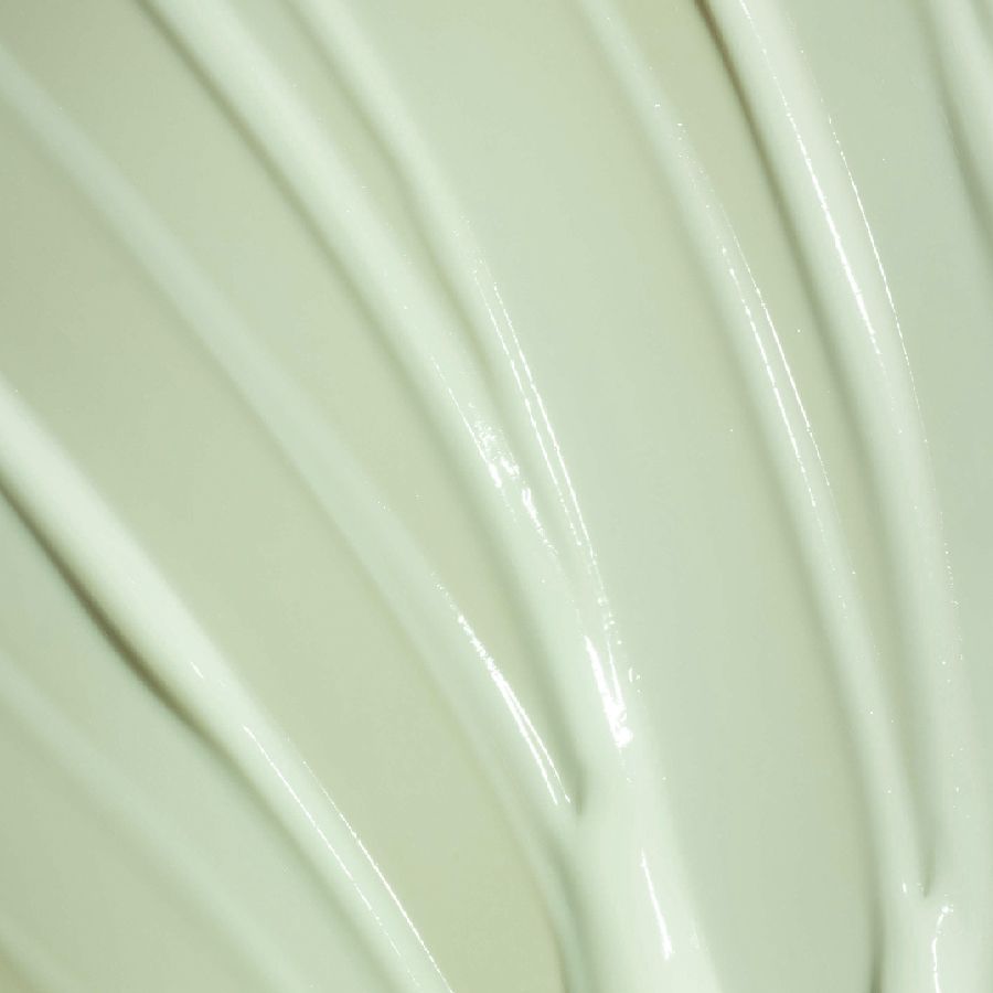 Nahaufnahme von hellgrüner Creme. Cremestriche in wellenförmigen Linien angeordnet.