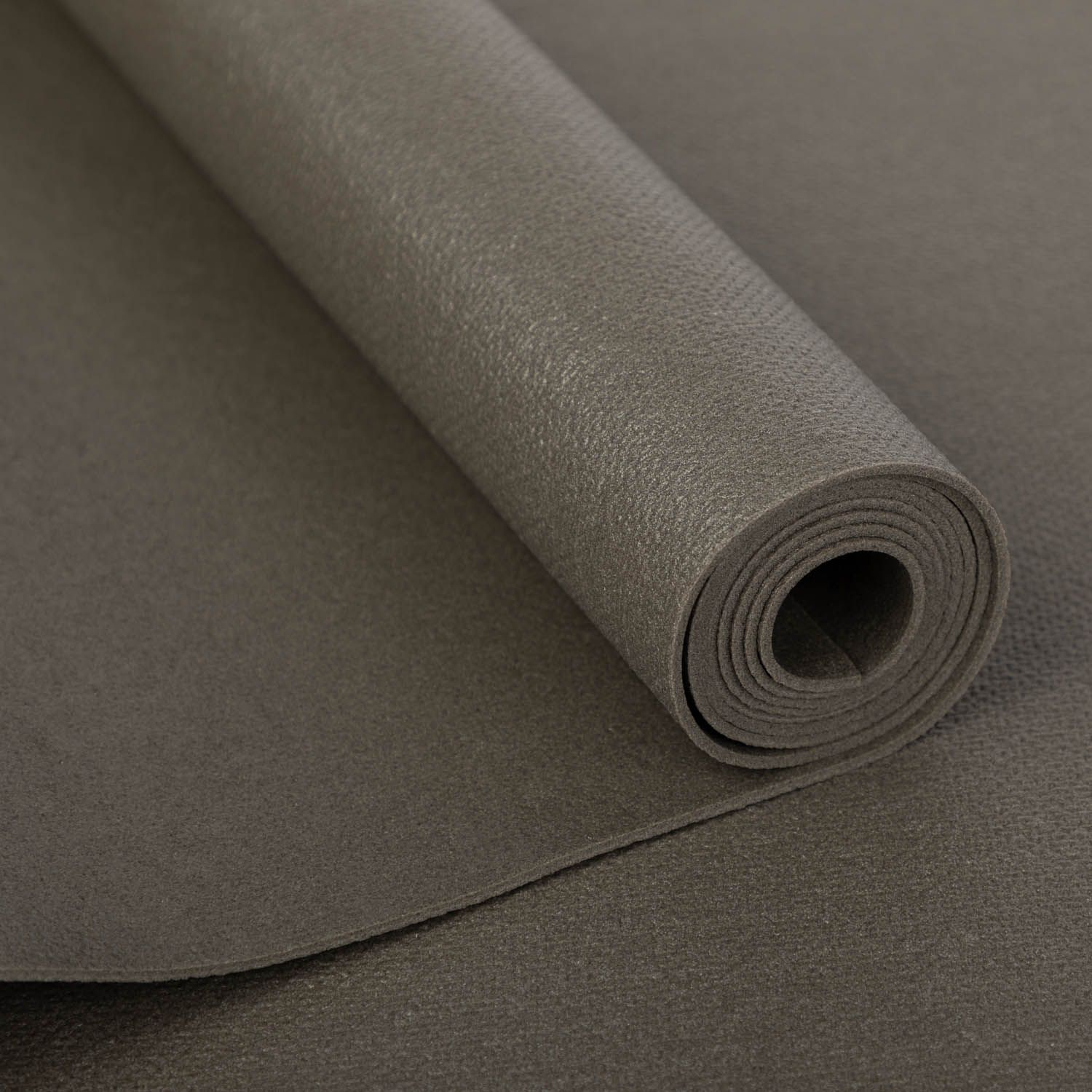 Gerollte graue Yogamatte. Auf weißem Hintergrund. Detailansicht der Oberfläche.