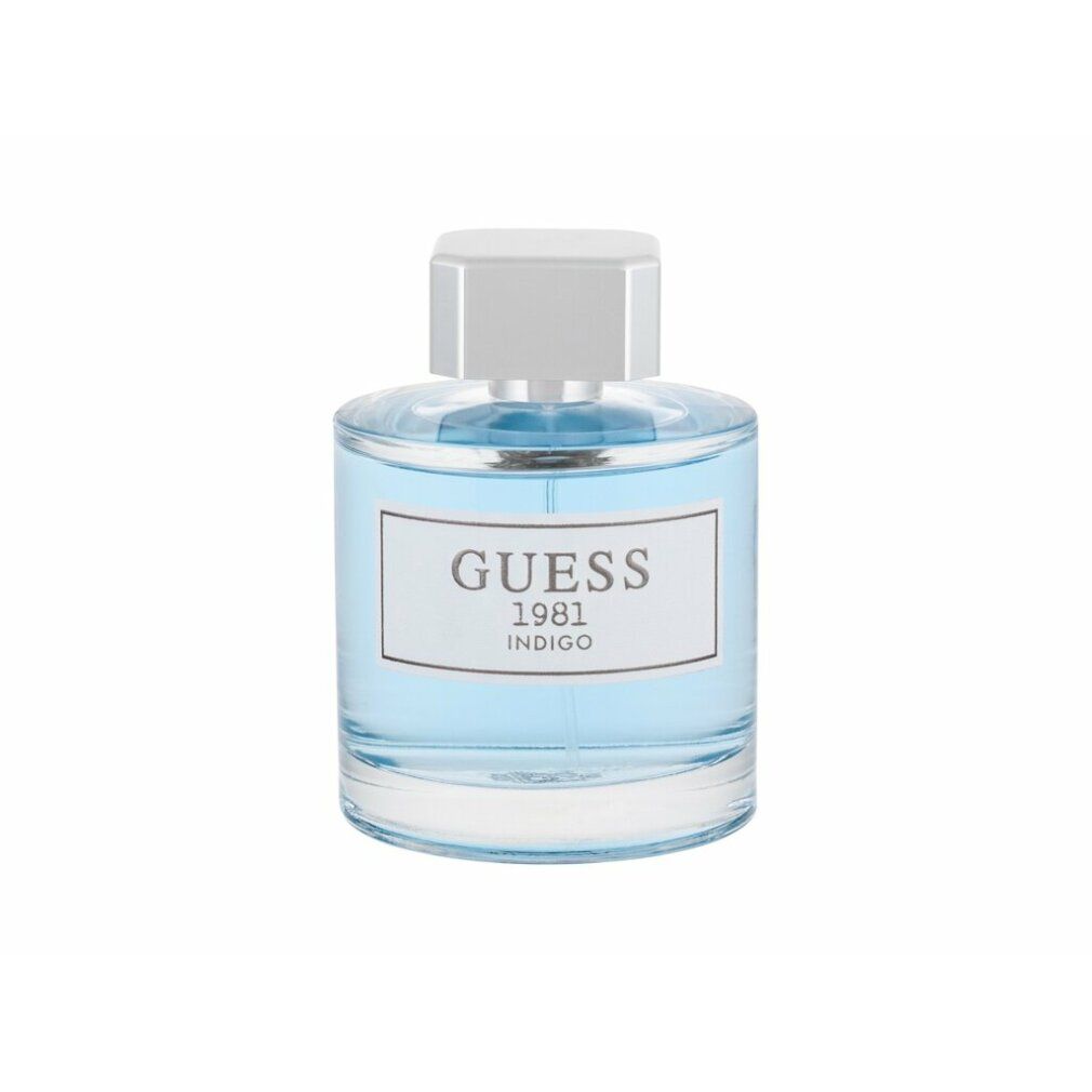 Hellblaues Parfümflakon mit weißem Etikett und Aufschrift "GUESS 1981 INDIGO". Weißer Verschluss.