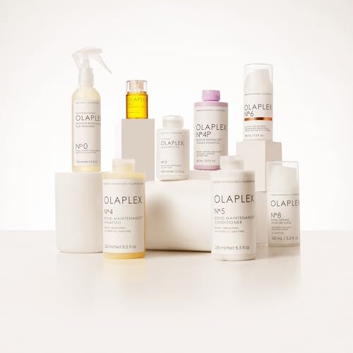 Verschiedene OLAPLEX-Haarpflegeprodukte auf weißen Podesten. Enthalten Flaschen, Tiegel und Sprays. Aufschrift: OLAPLEX.