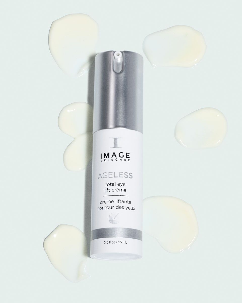 Creme-Kleckse um eine Flasche. Flasche: IMAGE Skincare, AGELESS total eye lift crème. 0.5 fl oz / 15 ml.