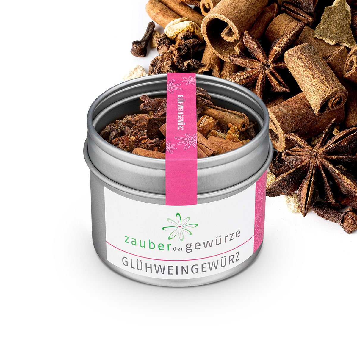 Metallbehälter mit Glühweingewürz. Rosa Etikett. Gewürze daneben. Sternanis, Zimtstangen.