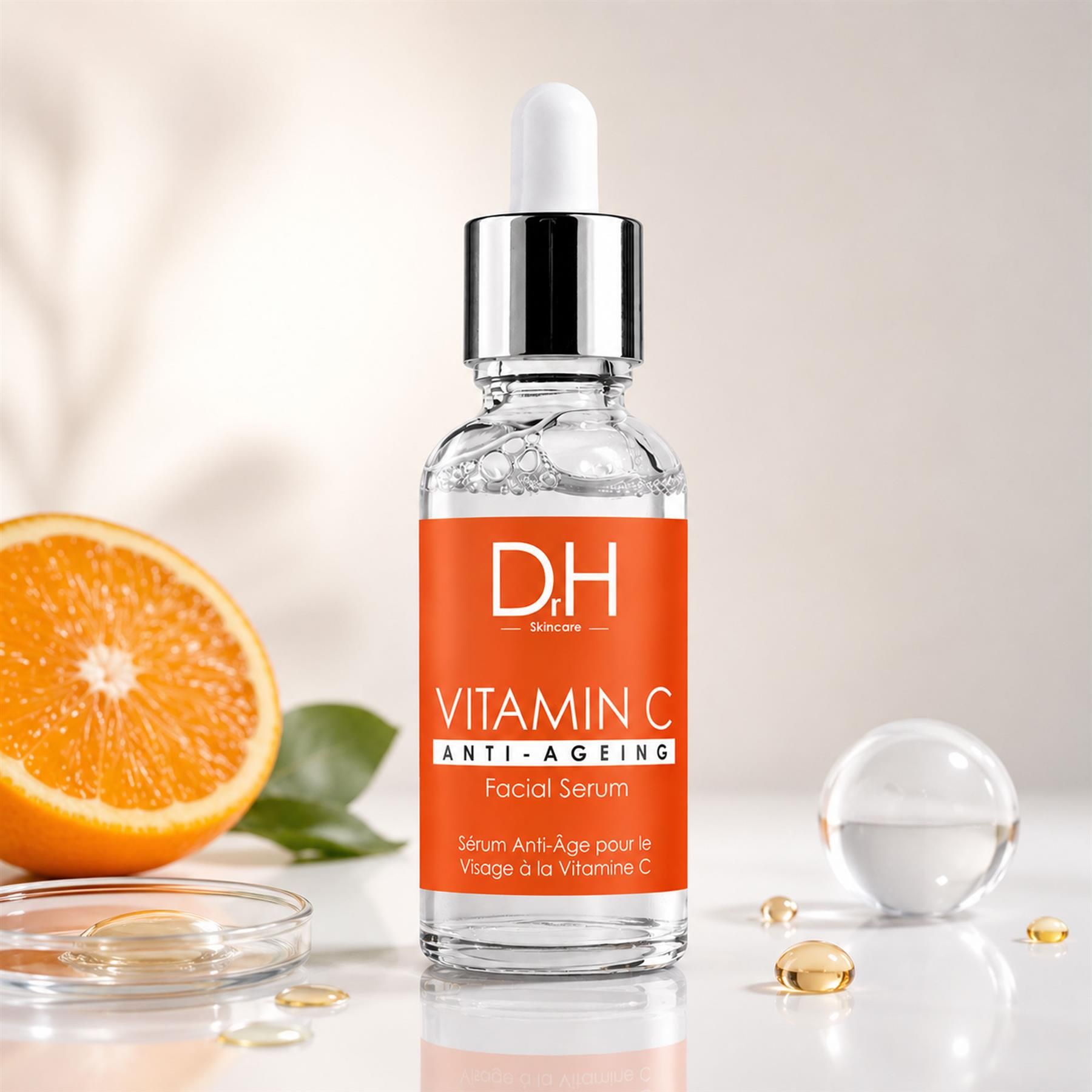 Dr H Anti-Aging Vitamin C Gesichtsserum mit Orangenscheibe, Kapseln und Glaskugel.