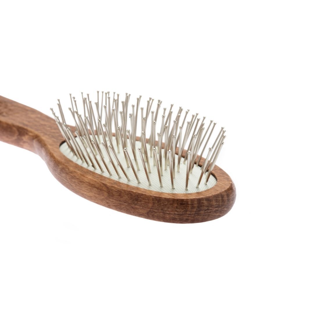 Nahaufnahme einer ovalen Bürste aus braunem Holz mit Metallstiften. Griff nicht sichtbar. Nippes Solingen.