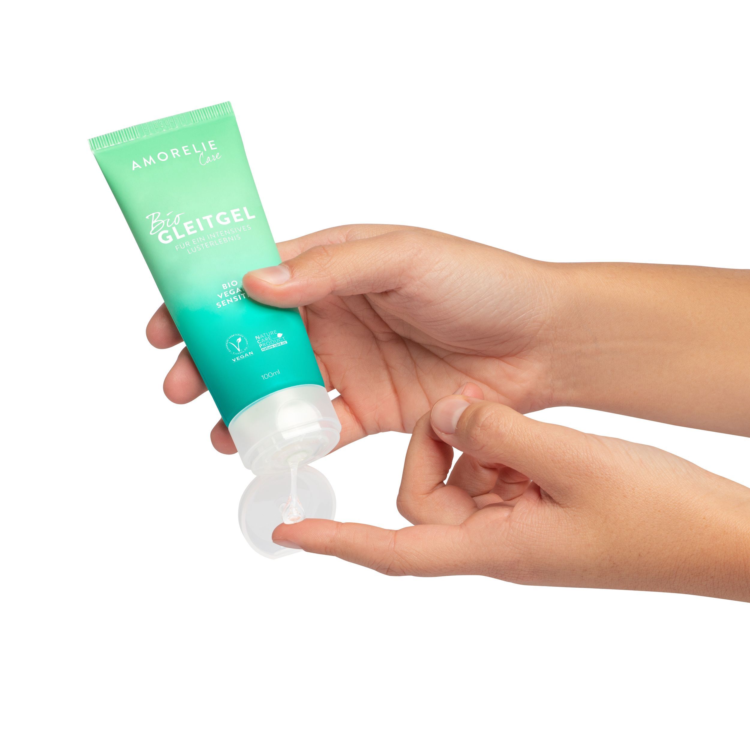 Mains tenant un tube vert. Inscription: AMORELIE Care, Bio Gleitgel, Bio Vegan Sensitiv. Label Vegan. Produit appliqué sur un doigt.