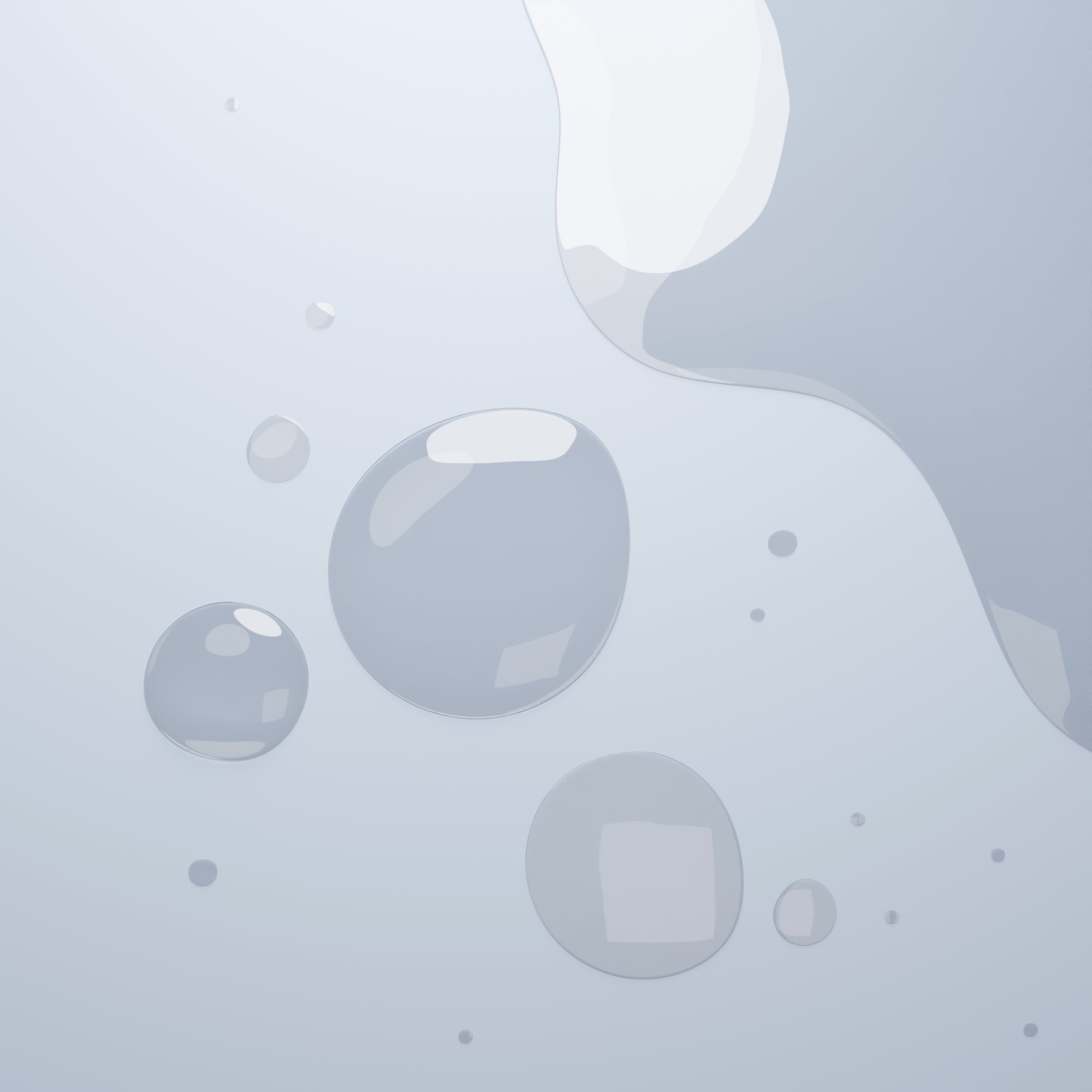 Mehrere Tropfen Flüssigkeit auf hellem Hintergrund. Runde und unregelmäßige Formen.