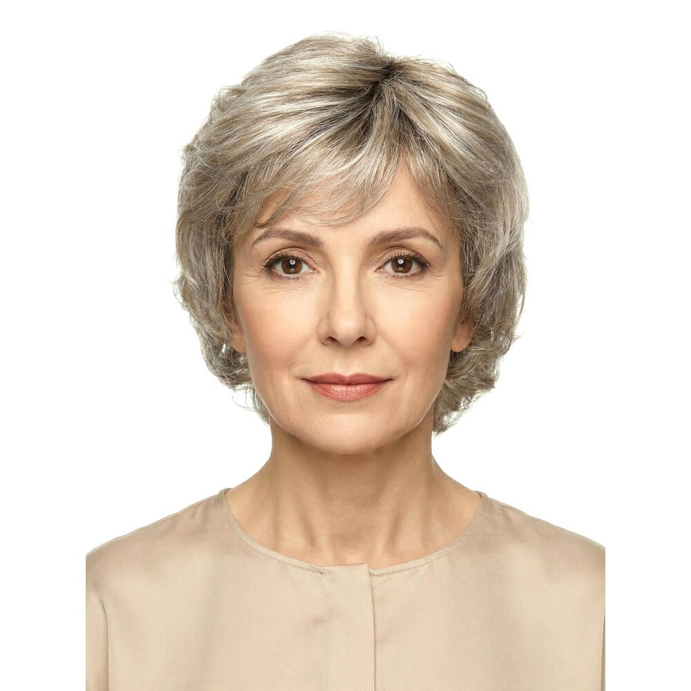 Kurzhaarperücke mit grauen Strähnen. Frontale Ansicht einer Frau mit beigem Oberteil. Haarschnitt mit Volumen.