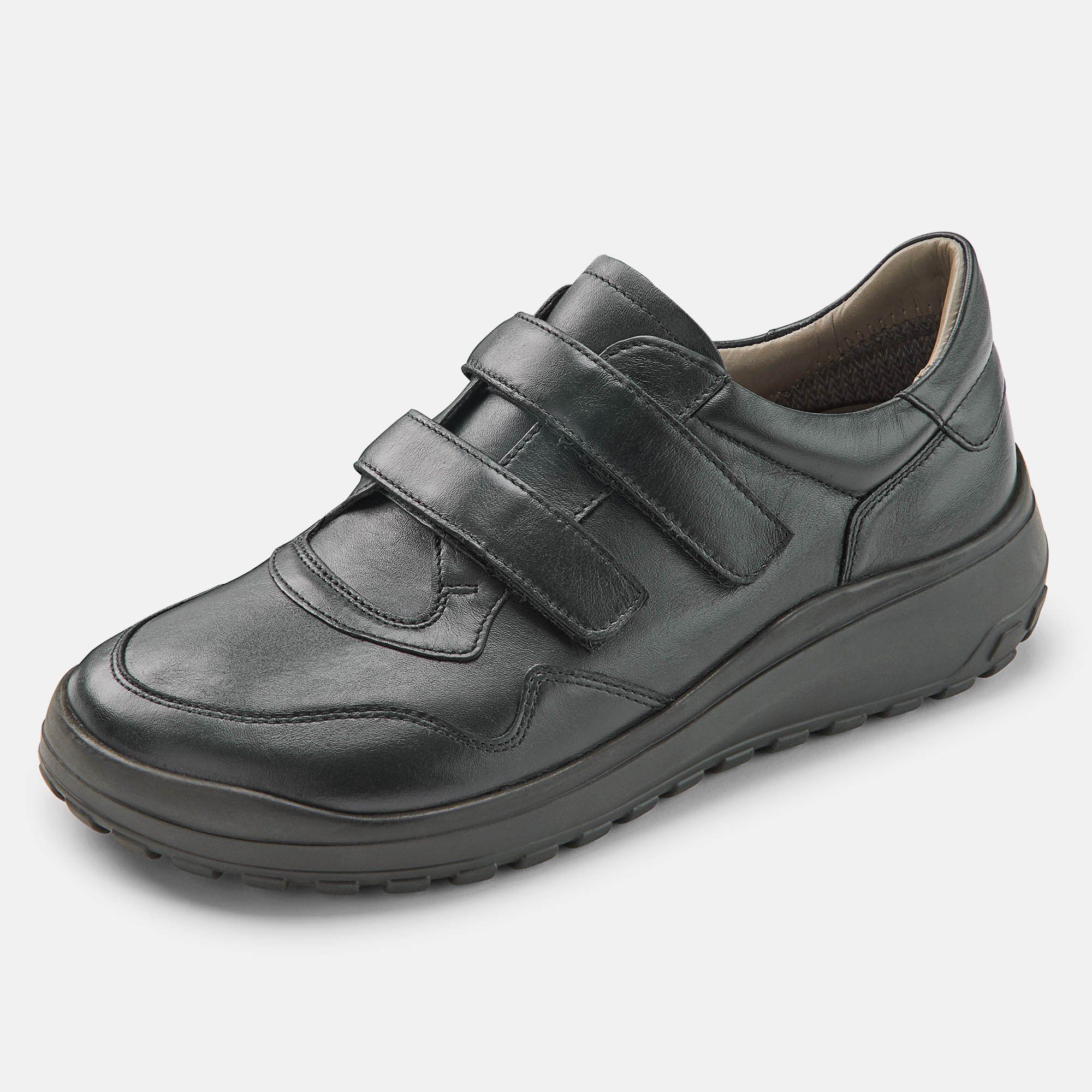 Schwarzer Herren-Slipper mit Klettverschluss. Breite Passform. Schuh von der Seite, leicht schräg gestellt.