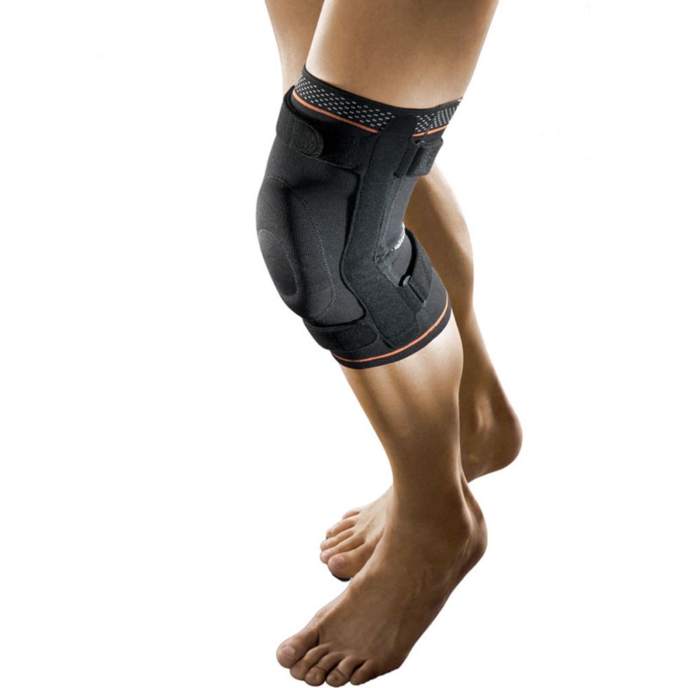 Schwarze Kniebandage mit Gelenkschienen am Bein. Orangefarbene Akzente. Klettverschlüsse. Auf hellem Hintergrund.