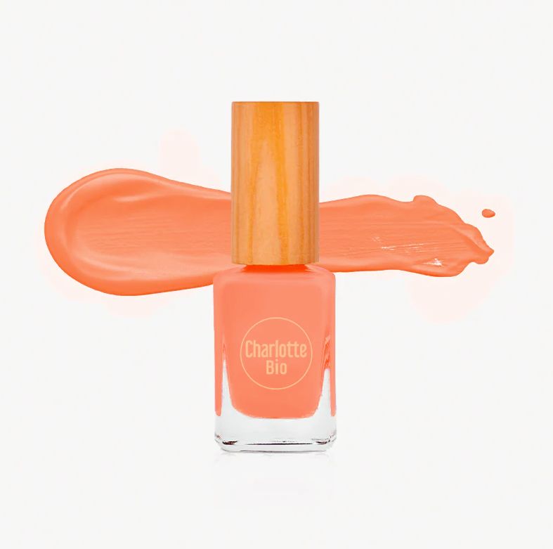 Nagellackflasche mit Holzdeckel und Farbstrich. Auf der Flasche steht "Charlotte Bio". Farbe: Pfirsich.