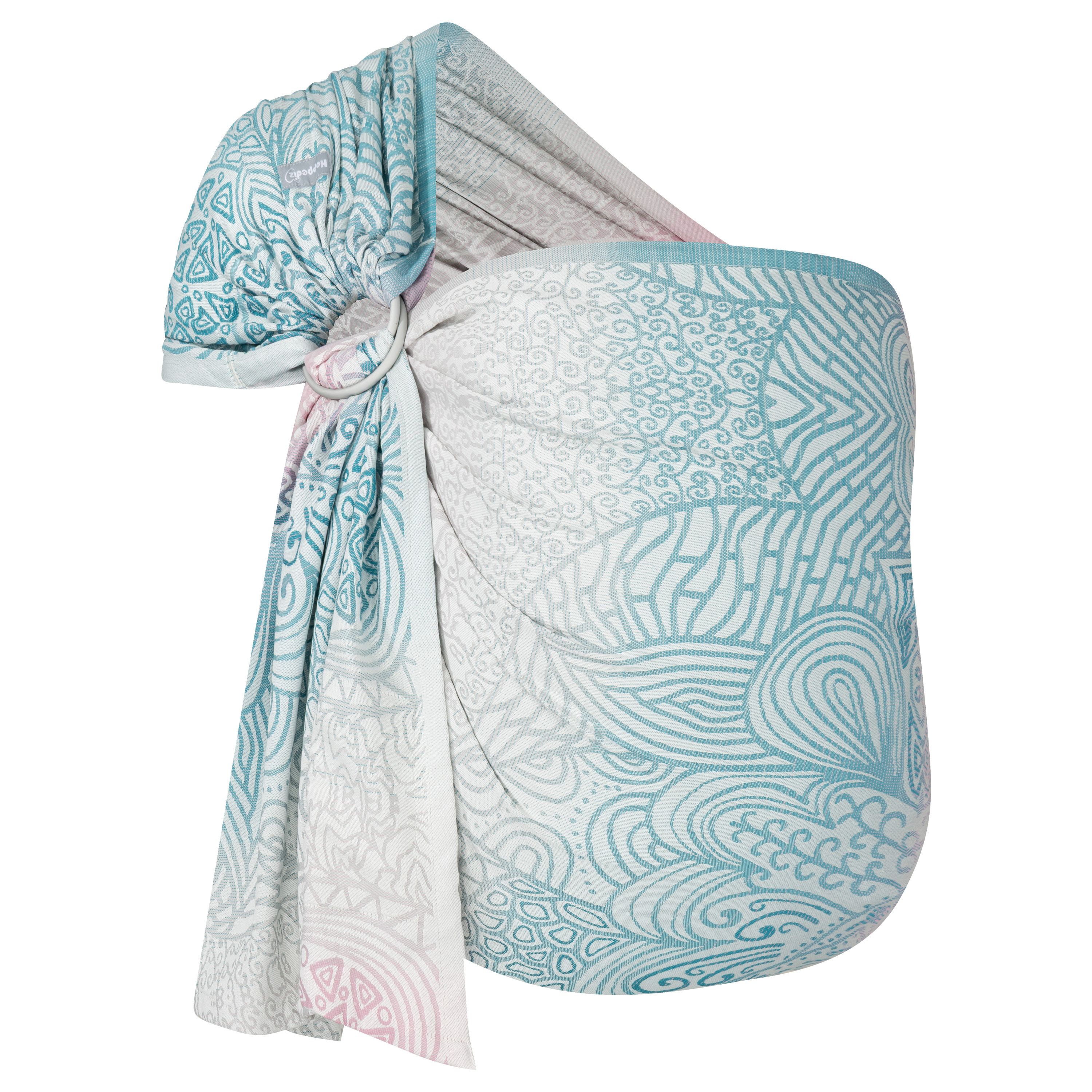Ring-Sling aus Stoff mit Muster in Türkis, Rosa und Weiß. Stoff durch Ringe gezogen.