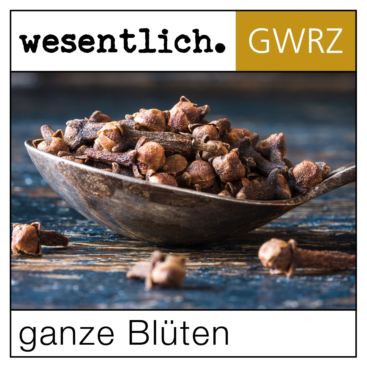 Löffel mit ganzen Nelkenblüten. Aufschrift: ganze Blüten. Hintergrund: Holzoptik.