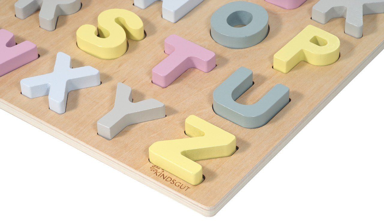 Nahaufnahme des Holzpuzzles mit Buchstaben. Buchstaben in Pastellfarben. Kindsgut-Logo unten rechts.
