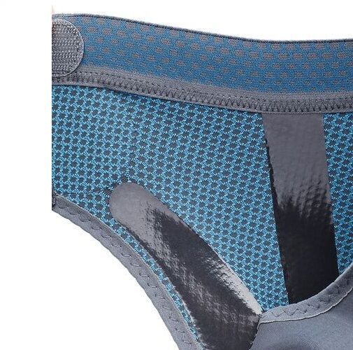 Nahaufnahme der Knöchelbandage. Blaues, strukturiertes Material mit grauen Details und Klettverschluss.