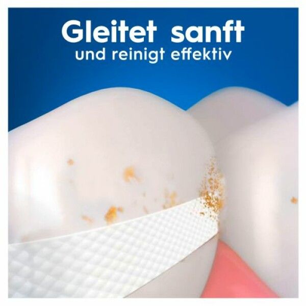 Nahaufnahme von Zähnen mit Zahnseide. Zahnseide zwischen den Zähnen. Text: Gleitet sanft und reinigt effektiv.