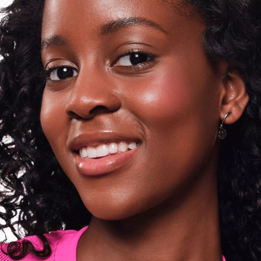 Porträt einer Frau mit Rouge auf den Wangen. Rosa Lippen. Dunkle Haut.