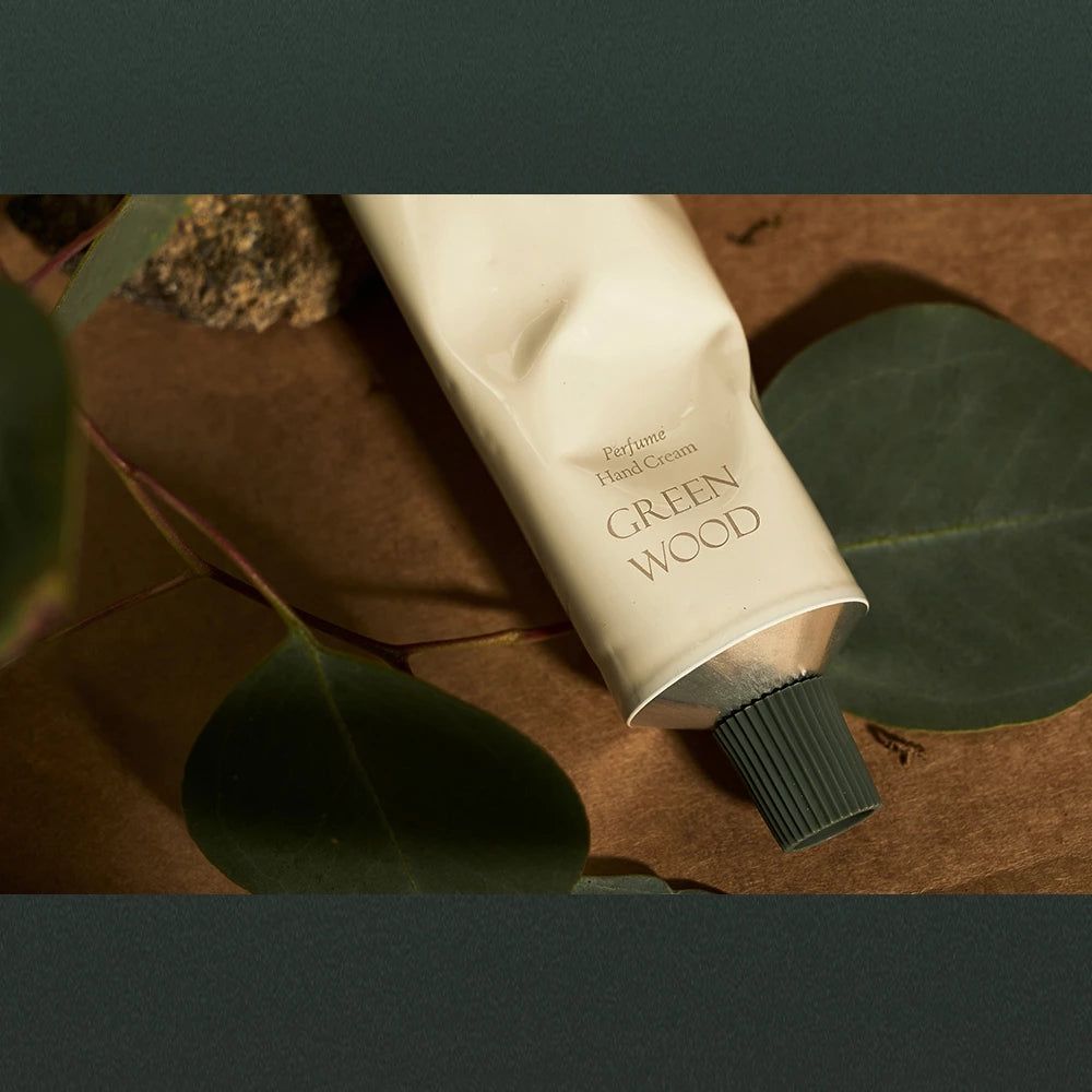 Eine cremefarbene Tube Handcreme mit der Aufschrift "GREEN WOOD".