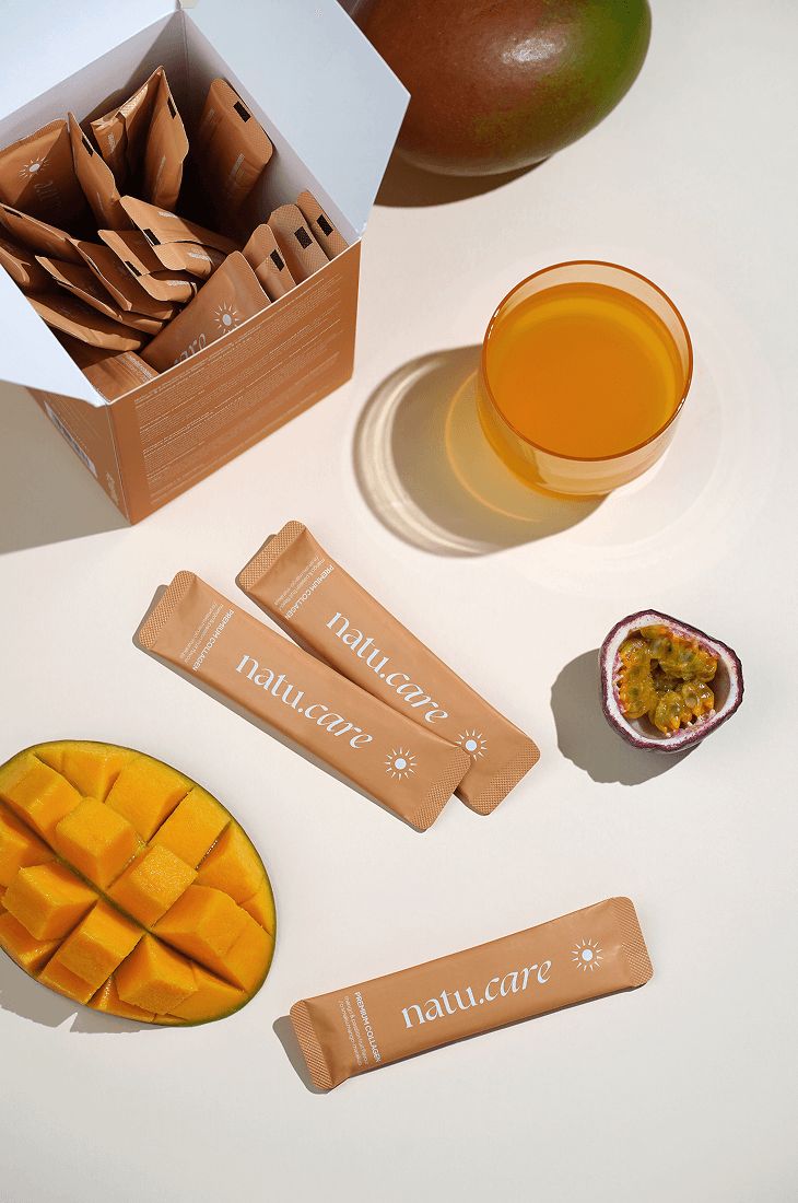 Produktbox, Beutel, Mango, Maracuja und Glas. Beutel mit Sonnenlogo. Box mit Premium Collagen.