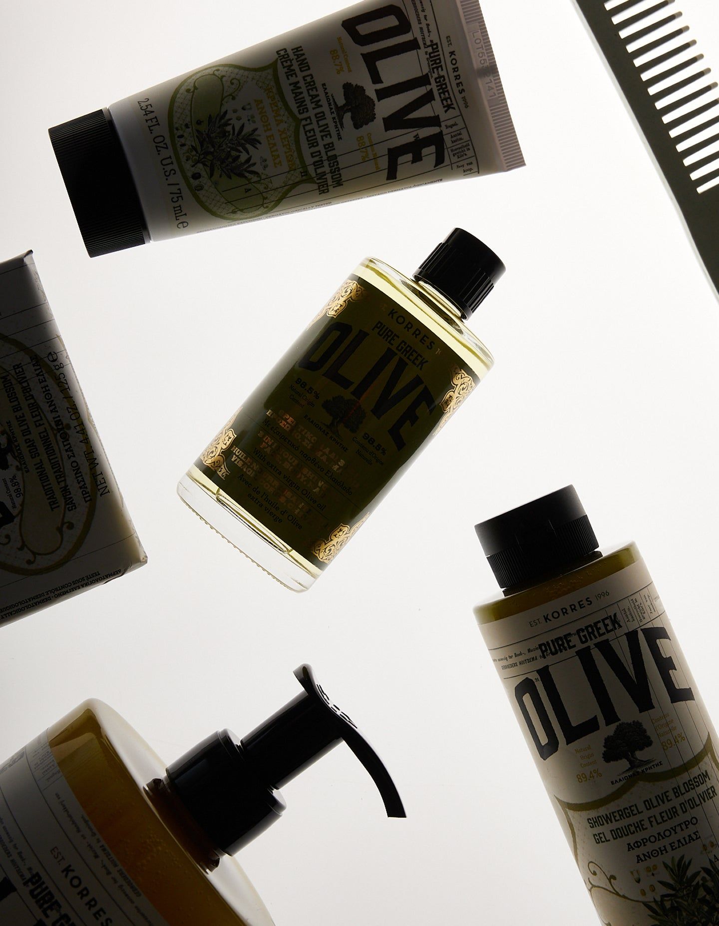 Verschiedene KORRES Olive Produkte: Flaschen, Tube und Seife. Schwarze Deckel, grüne Etiketten, weißer Hintergrund.