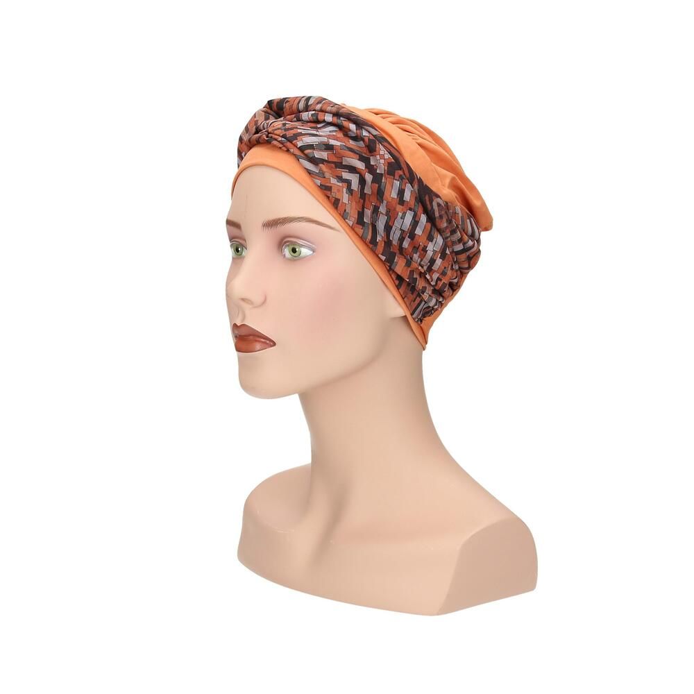 Turban mit orangefarbenem Unterteil und gemustertem Oberteil. Auf einer Schaufensterpuppe, Seitenansicht.