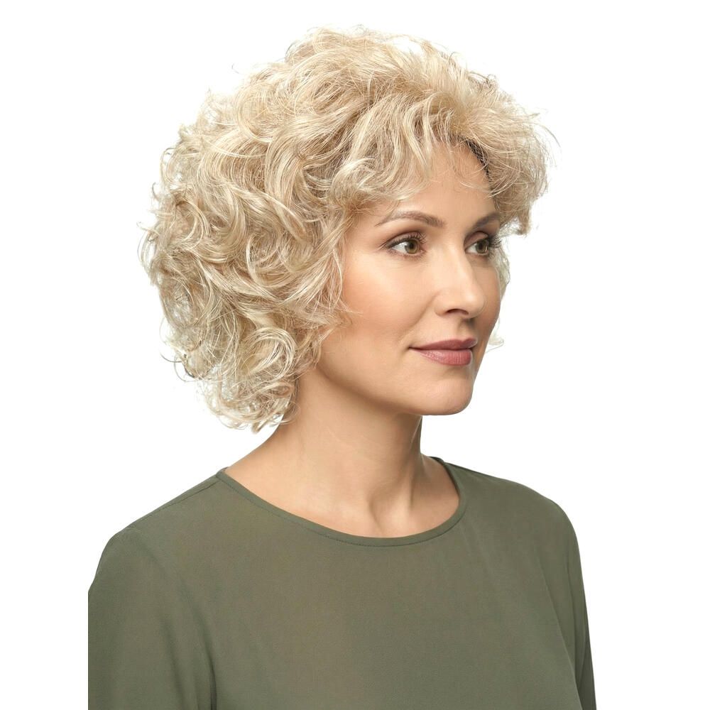 Perücke mit lockigem, blondem Haar. Die Frau trägt ein grünes Oberteil. Seitenansicht.