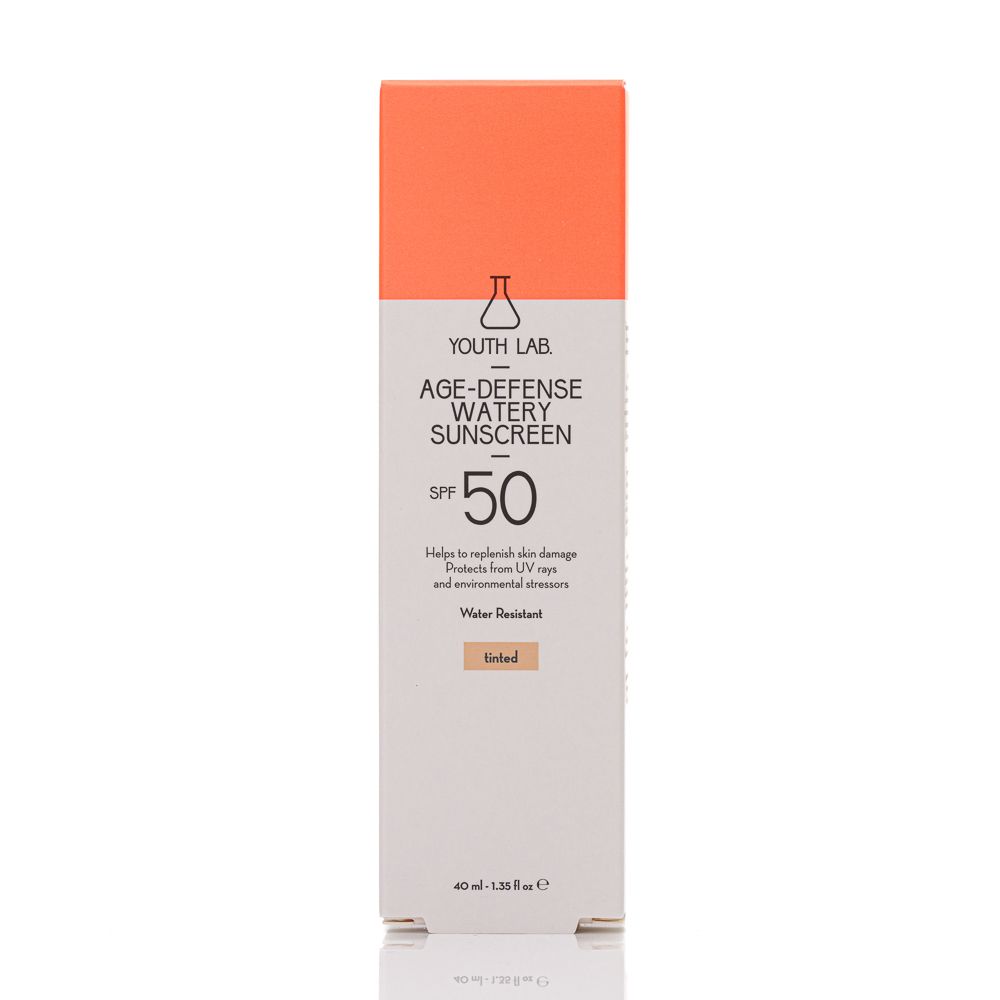 Verpackung YOUTH LAB Age Defense Watery Sunscreen SPF50 Tinted. Weiß, orange und beige. Text: SPF 50, Water Resistant, Getönt.