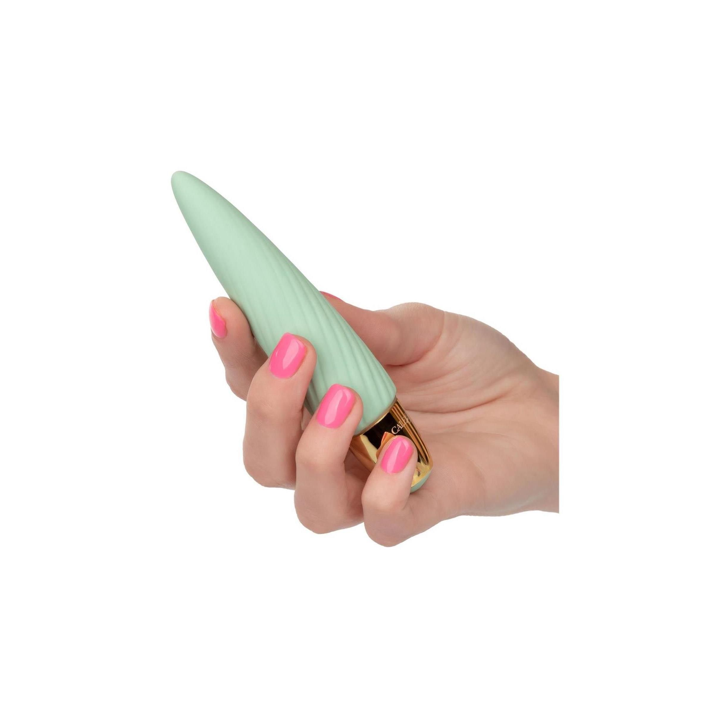 Minzfarbener Vibrator mit goldfarbenem Sockel. In einer Hand gehalten. Rosa lackierte Fingernägel.