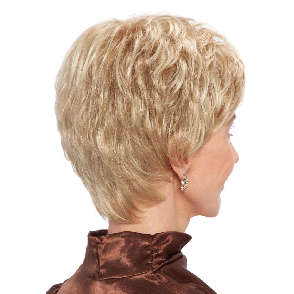 Blond gefärbte Perücke. Kurzer, gestufter Schnitt. Frau mit brauner Bluse. Seitenansicht.