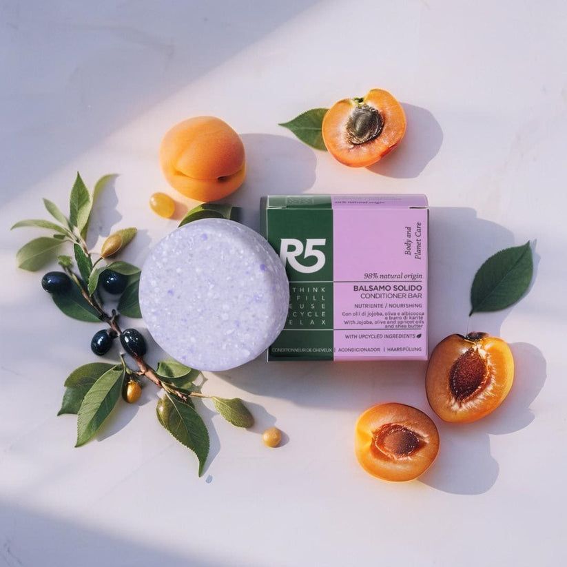 Runder, lila Festbalsam und Verpackung. Text: R5, Balsamo Solido Capelli, Origine Naturale. Mit Aprikosen und Blättern dekoriert.