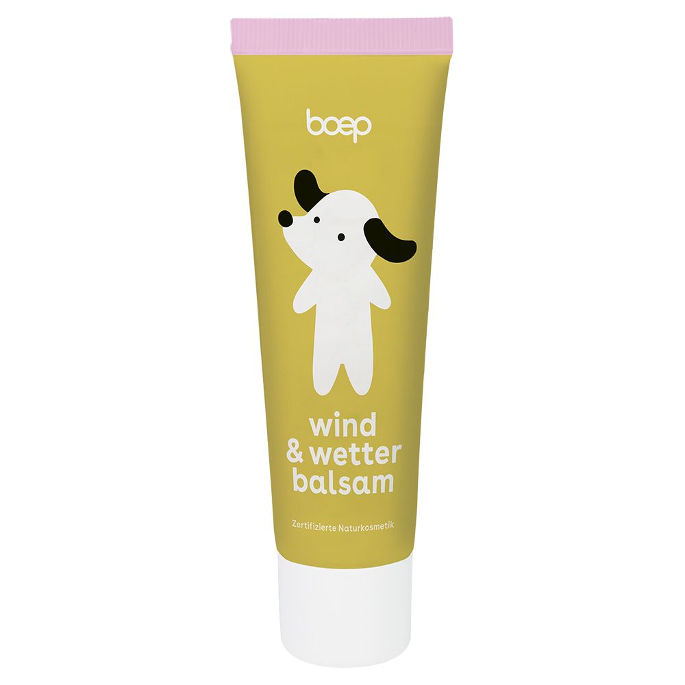 Gelbe Tube mit Hund-Illustration. Text: "wind & wetter balsam". Rosa Deckel. Weißer Boden. Zertifizierte Naturkosmetik.