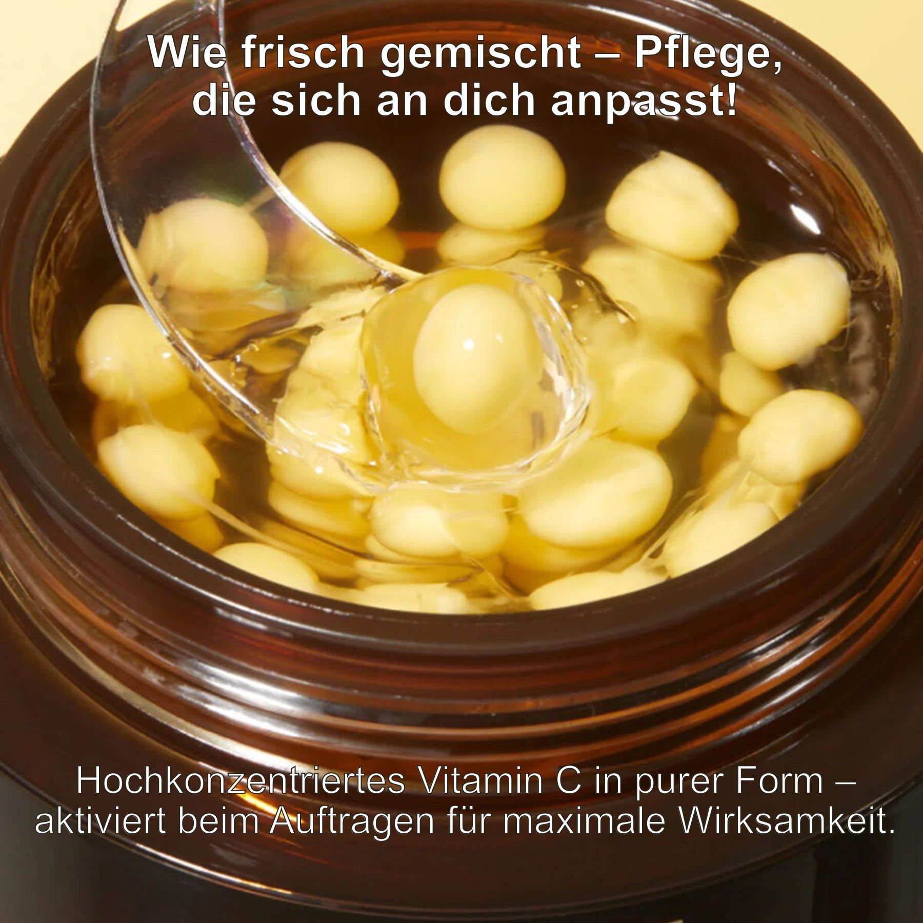 Offener Tiegel mit Creme und gelben Kapseln. Löffel mit einer Kapsel. Text: Hochkonzentriertes Vitamin C in reiner Form.