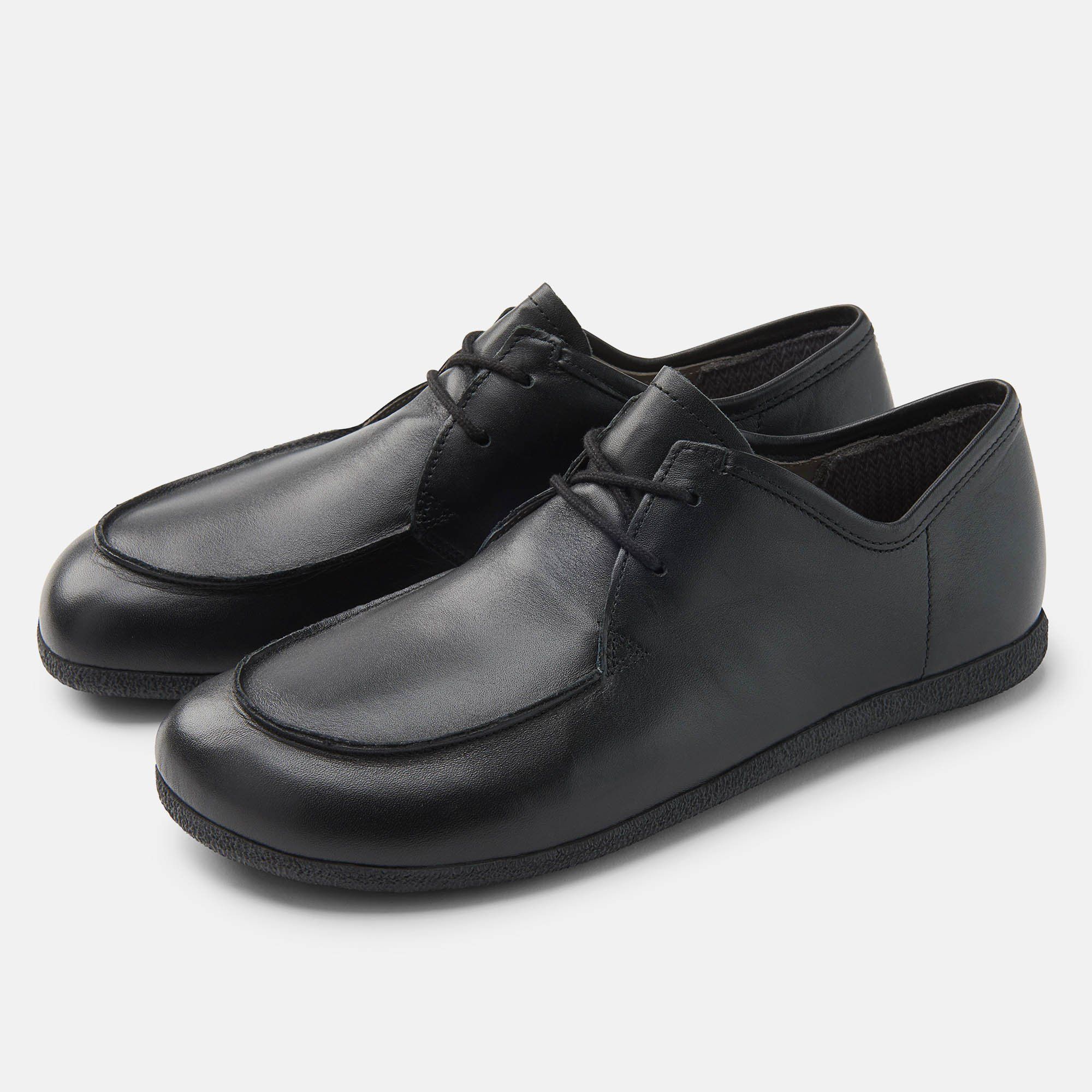 Schwarze Schnürschuhe, breite Passform. Glattes Leder, runde Zehenkappe, flache Sohle. Schnürsenkel. Paar Schuhe.