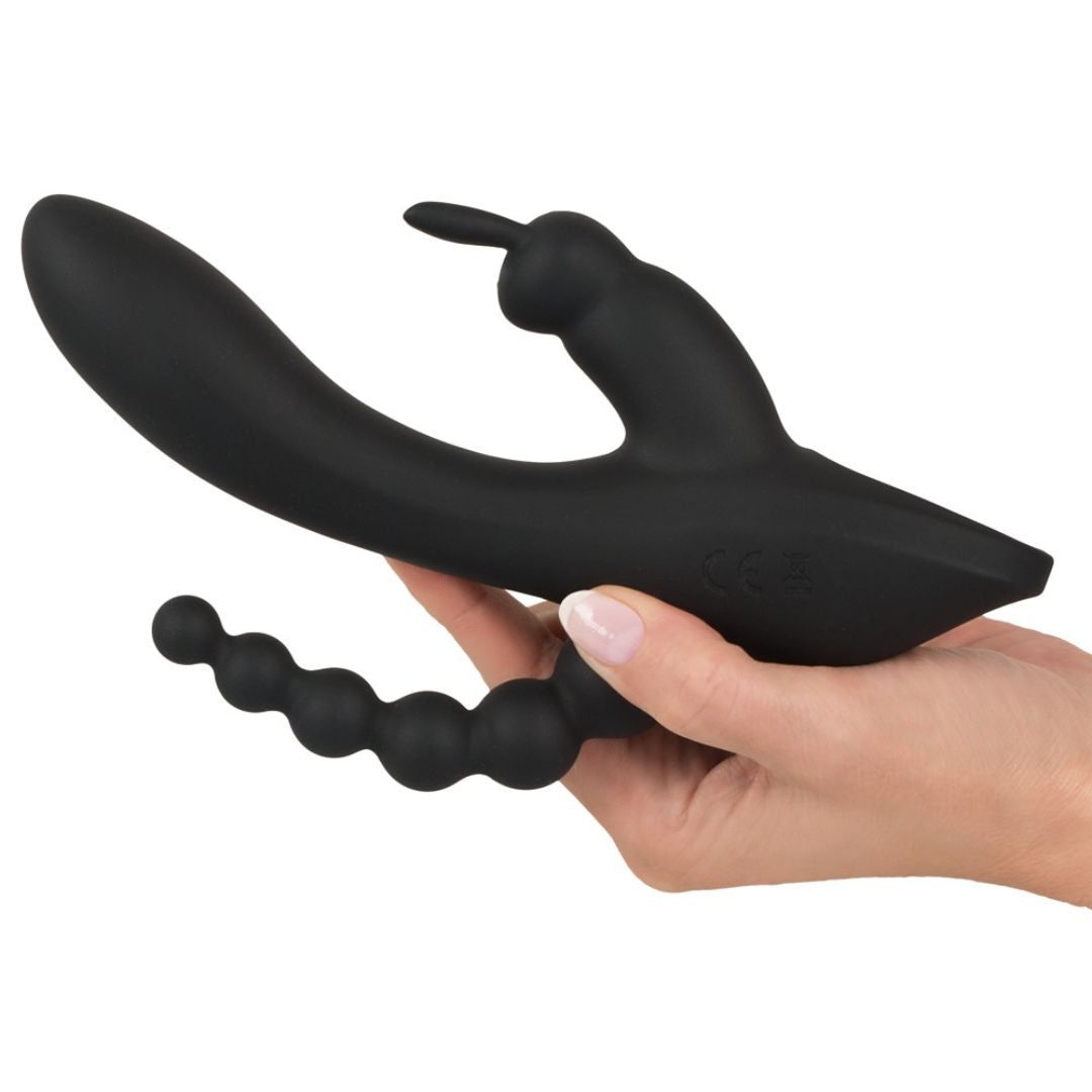 Schwarzer Vibrator in Frauenhand gehalten. Er hat eine gebogene Form und einen kugelförmigen Abschnitt.