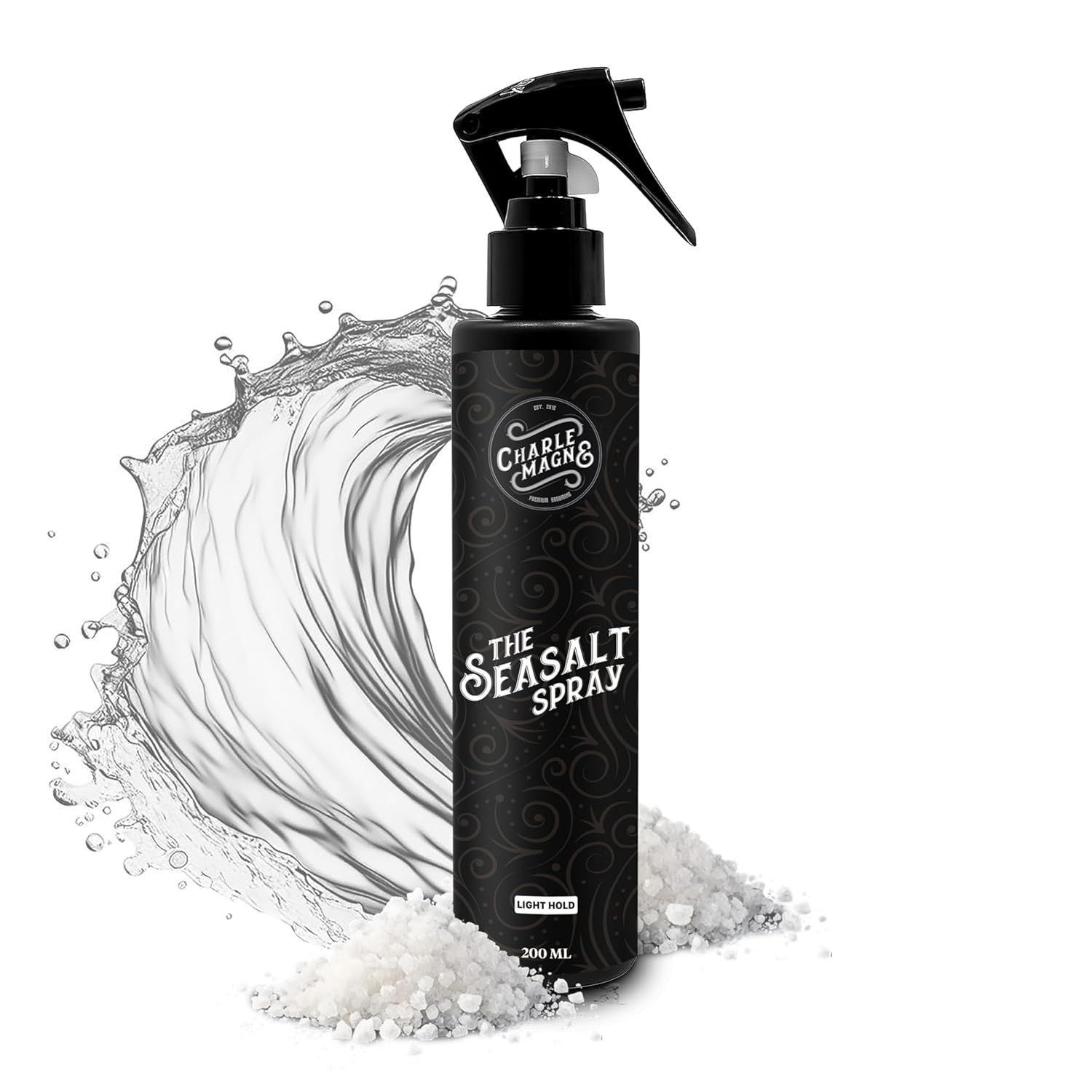 Schwarze Sprühflasche mit Aufschrift "THE SEASALT SPRAY". Wasser und Salz im Hintergrund. Marke: Charlemagne.