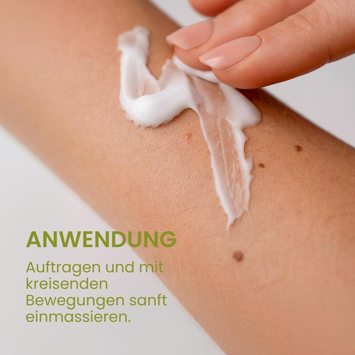 Hand trägt weiße Creme auf Arm auf. Text: Anwendung: Auftragen und mit kreisenden Bewegungen sanft einmassieren.