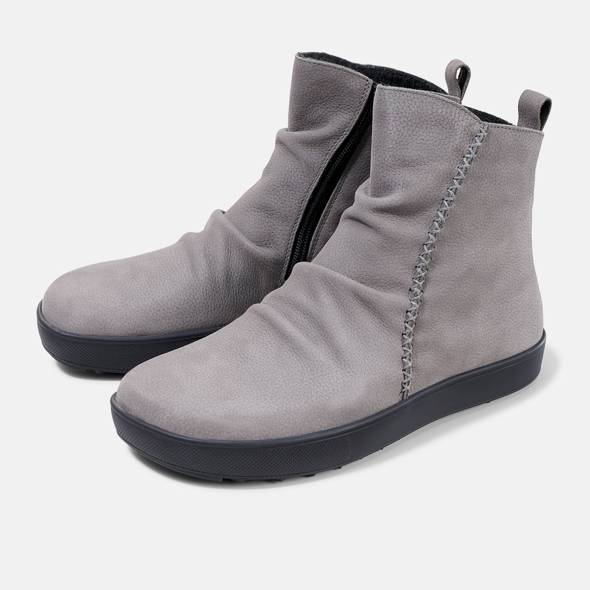 Graue Stiefelette mit schwarzer Sohle. Seitlicher Reißverschluss, Ziernähte. Faltenwurf am Schaft.