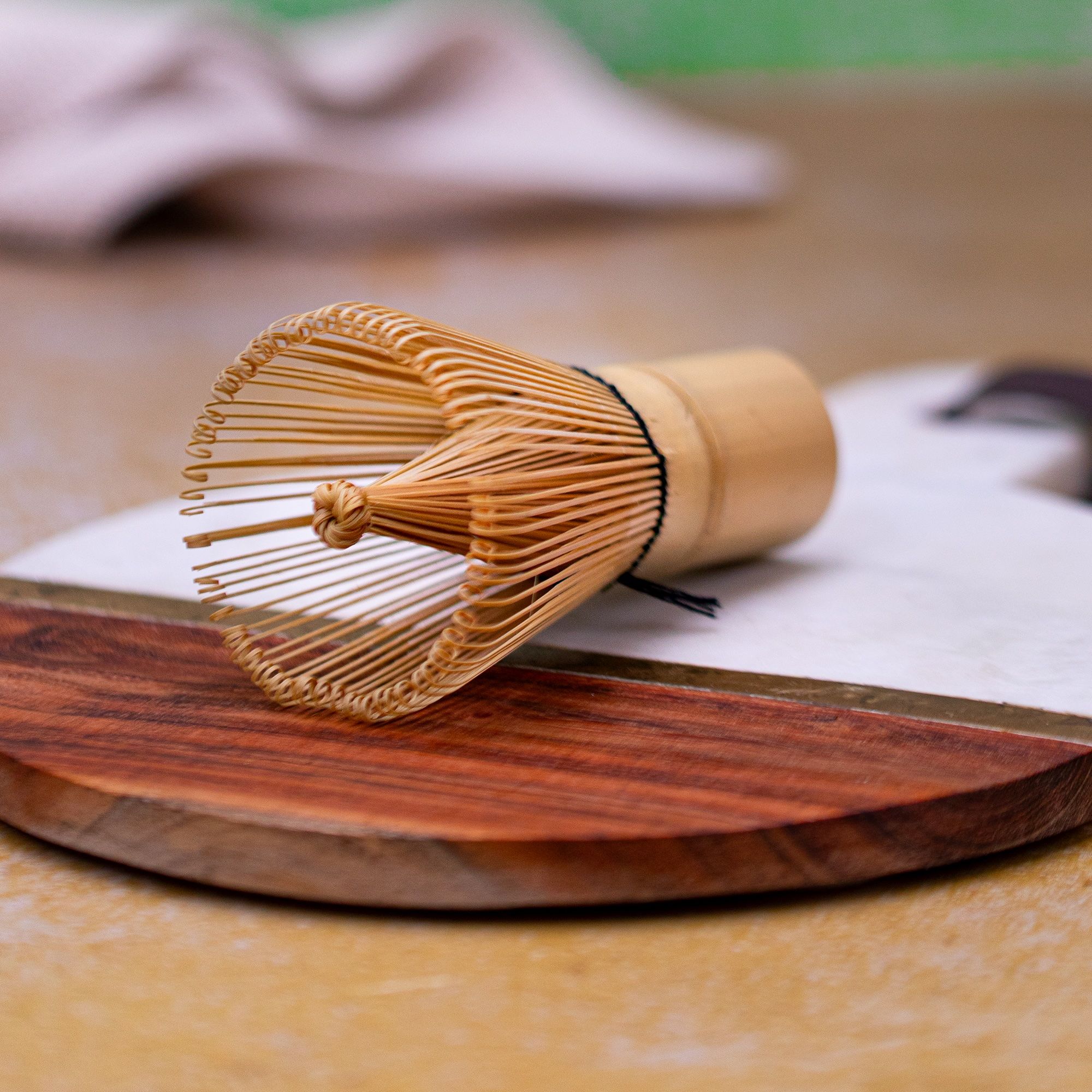 Matcha Bambusbesen auf Holz-Marmor-Brett. Bambusborsten, Holzgriff.