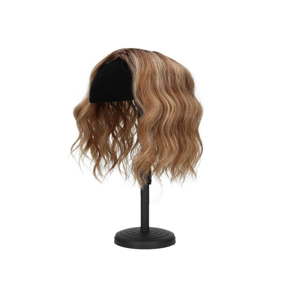 Haarteil mit gewelltem Haar, auf einem schwarzen Ständer. Blonde und braune Farbtöne.