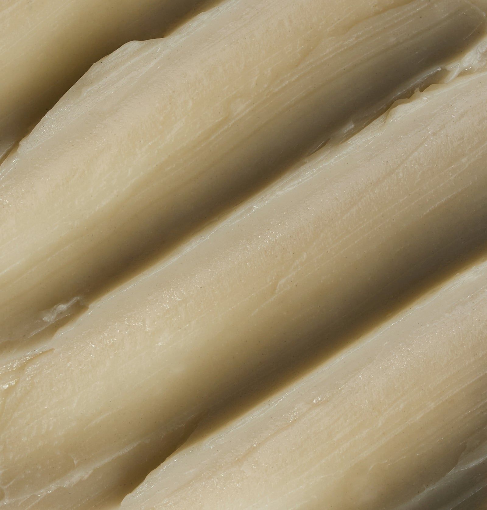 Nahaufnahme von vier hellen, länglichen Objekten. Sie sind parallel angeordnet und haben eine geriffelte Oberfläche.