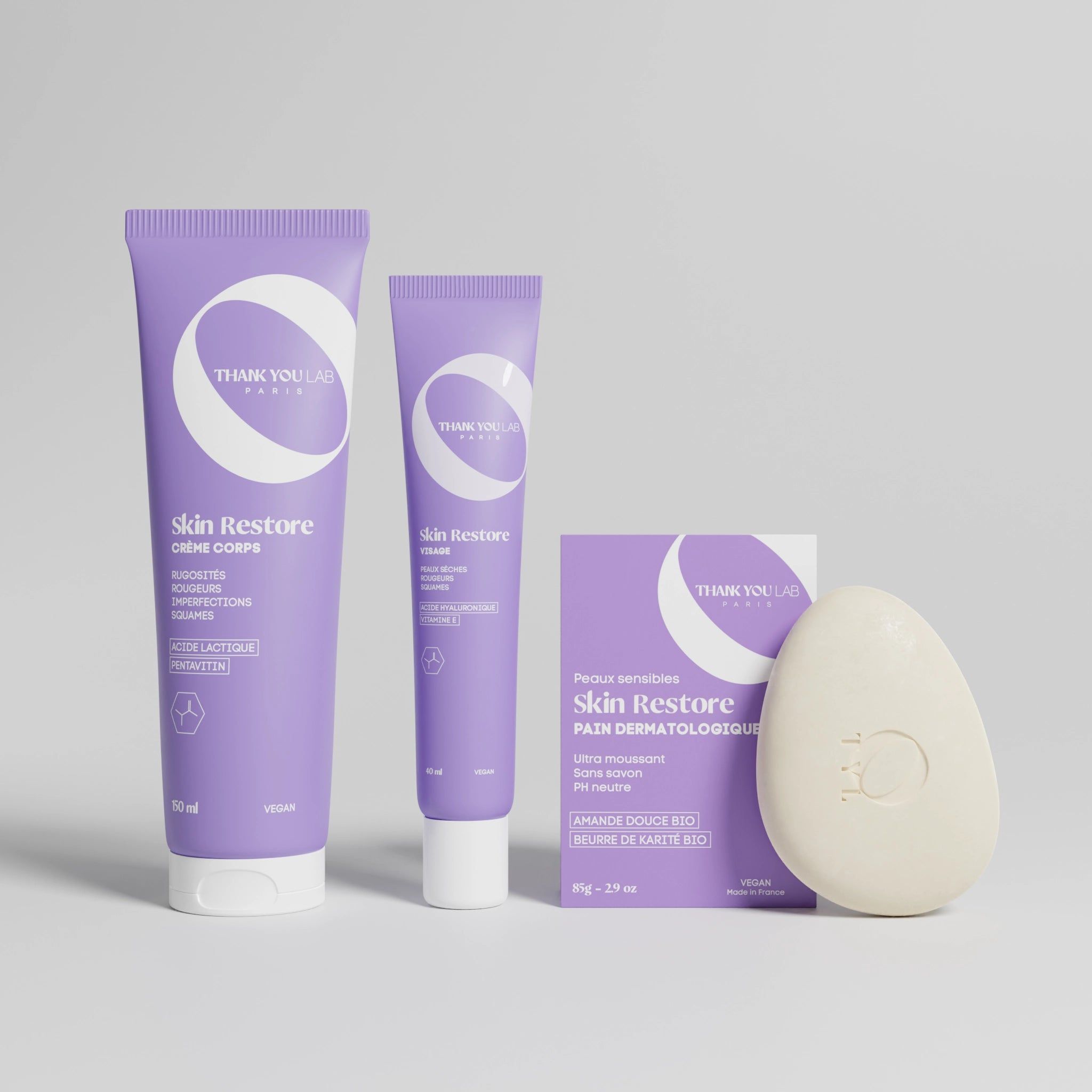 Drei lila Tuben und eine ovale Seife. Auf den Produkten steht "Skin Restore".