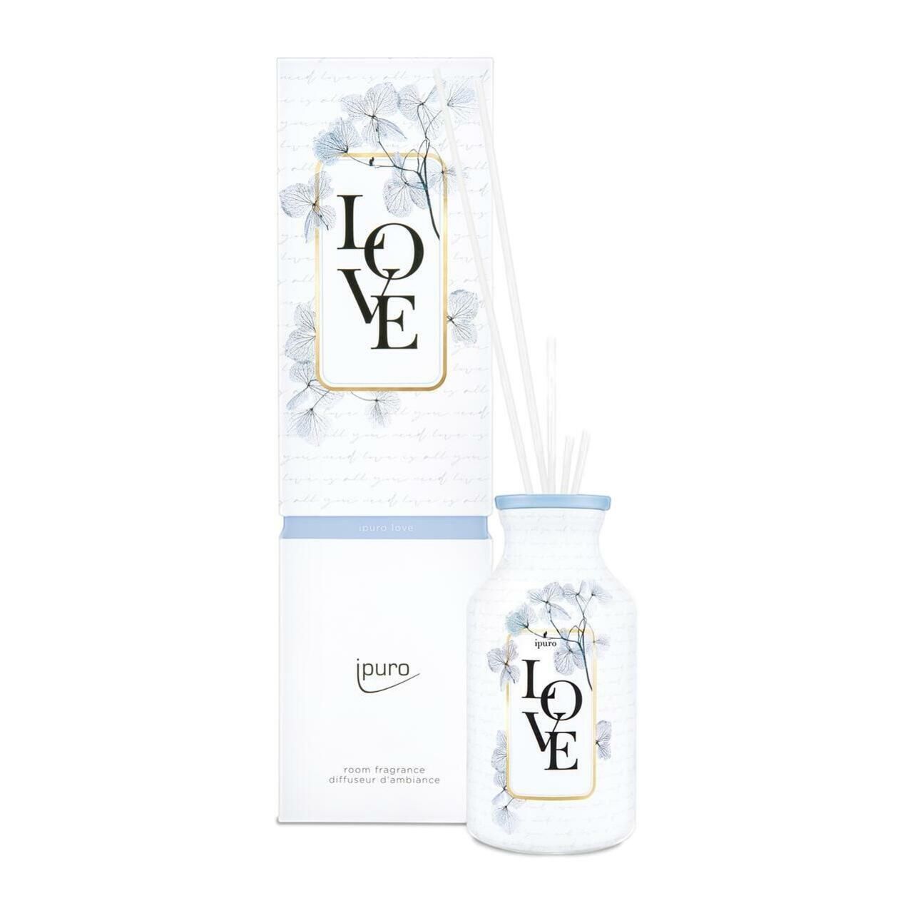Raumduft-Diffusor mit weißer Flasche und Stäbchen. Aufschrift "LOVE" und "ipuro". Karton mit floralem Muster.