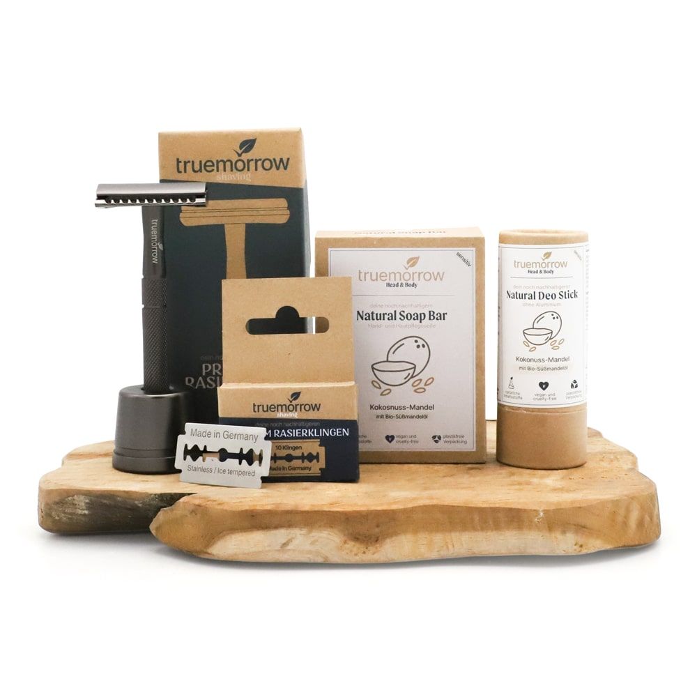 Geschenkset mit Rasierer, Rasierklingen, Seife und Deostick. Produkte auf Holzbrett. Verpackungen mit "truemorrow"-Logo.