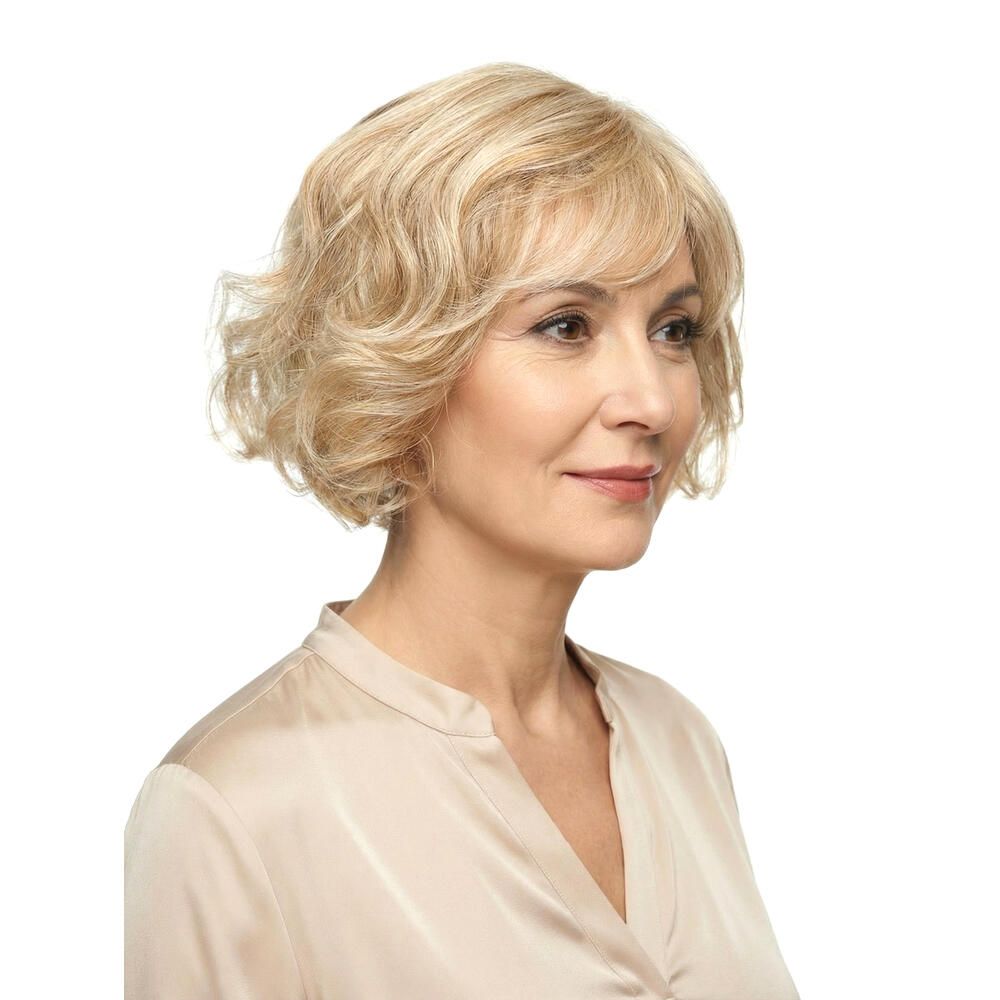 Blonde Perücke mit Pony, welligem Haar. Frau im Profil, beiges Oberteil.