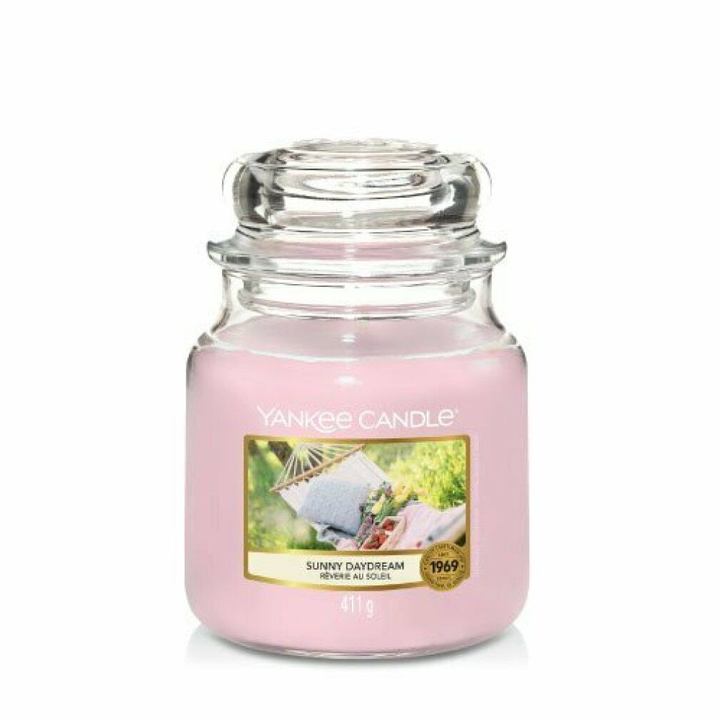 Yankee Candle Duftkerze Sunny Daydream. Rosa Kerze im Glasbehälter mit Deckel. Etikett mit Bild einer Hängematte. Gewicht: 411 g.