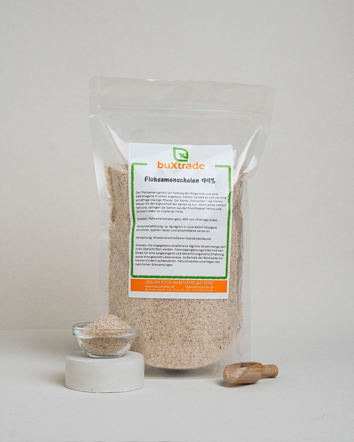 Verpackung mit buXtrade Flohsamenschalen, kleine Schale, Holzschaufel. Produkt auf weißem Hintergrund.