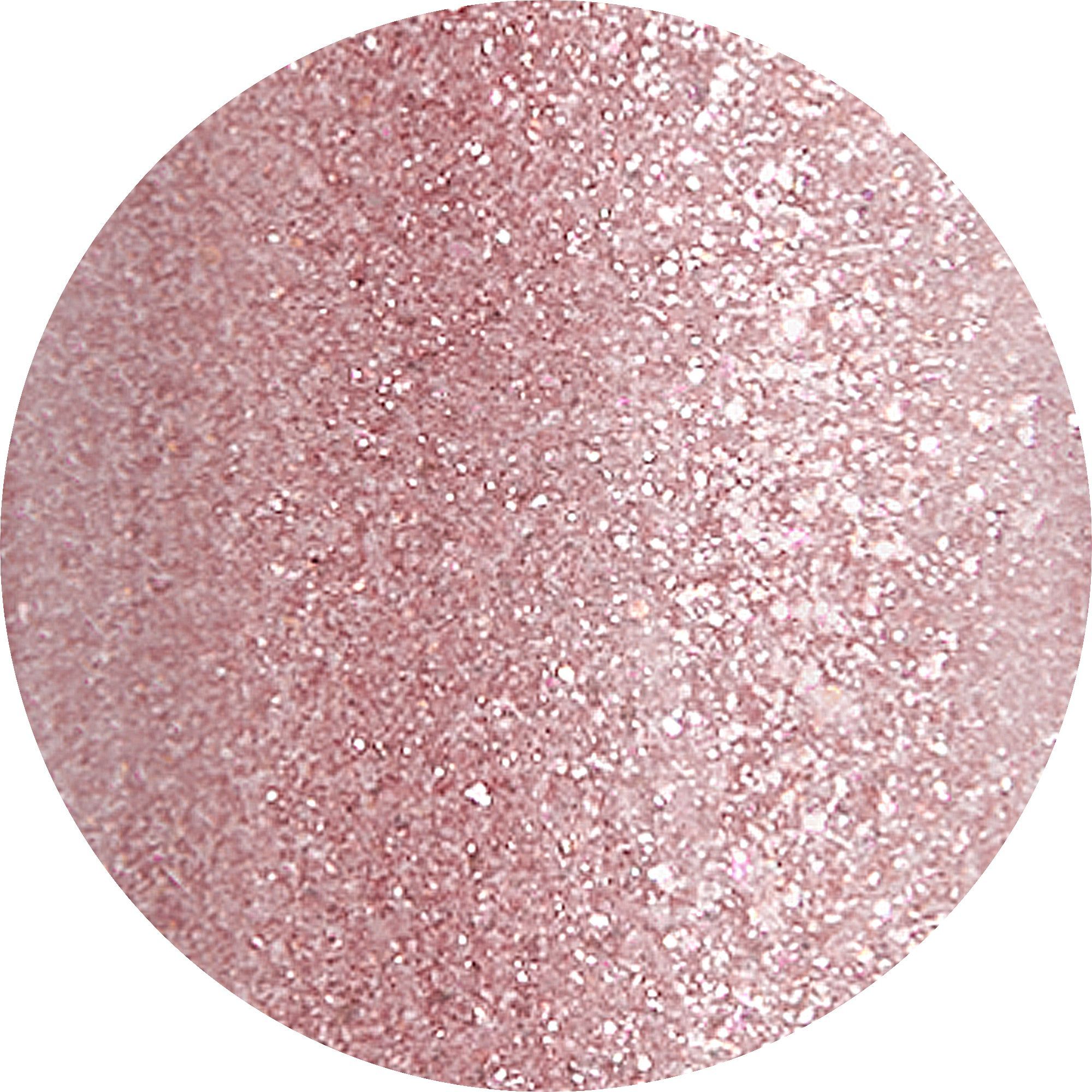 Primo piano di glitter rosa a forma circolare. I glitter sono fini e distribuiti uniformemente.