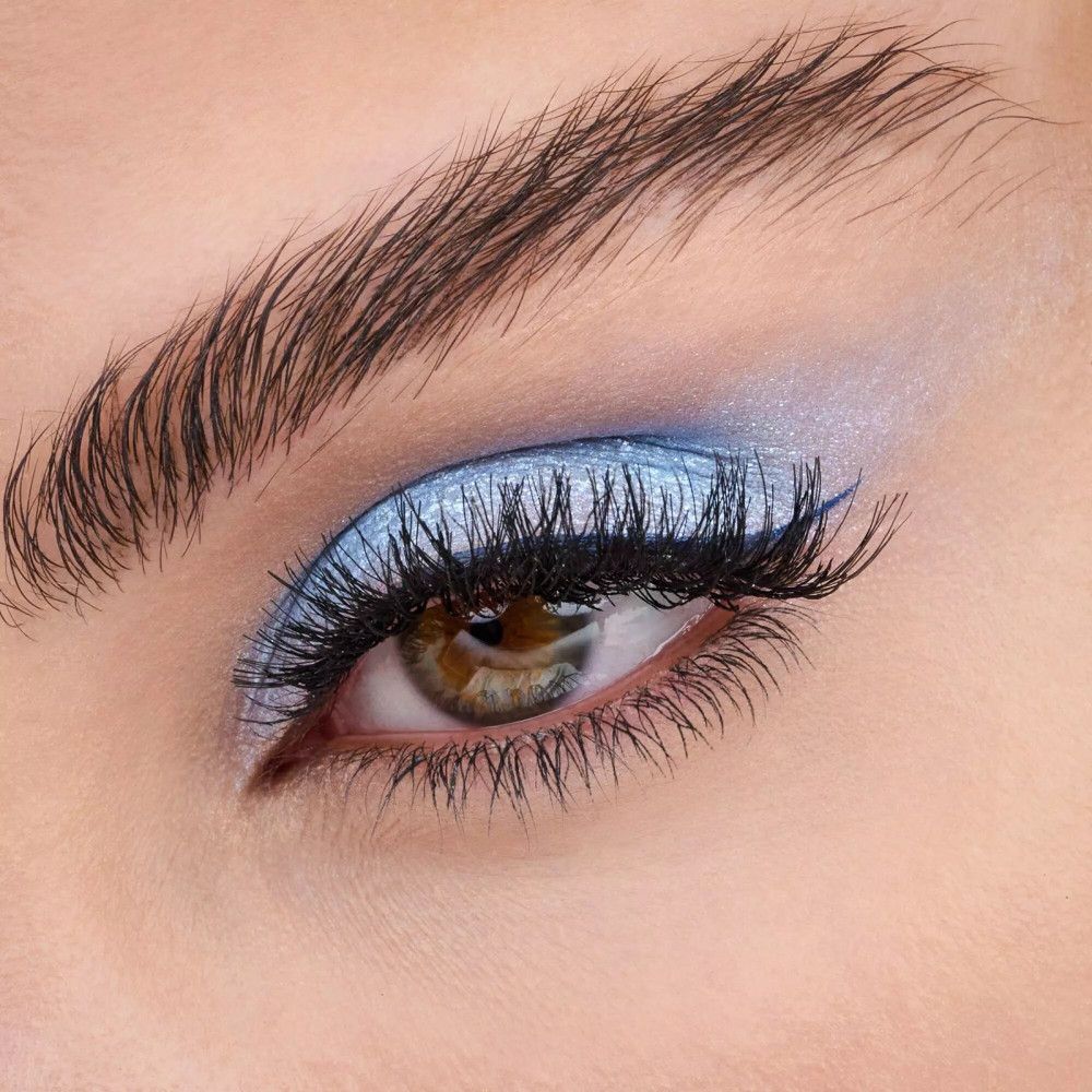 Nahaufnahme eines Auges mit falschen Wimpern und blauem Lidschatten.
